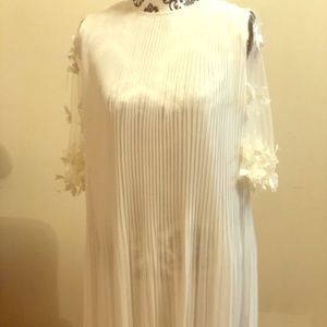All white dress, with flowers stitched on the arm